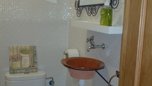 Un baño pequeño con inodoro, lavamanos y espejo.