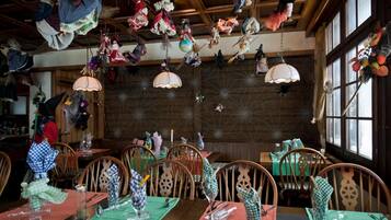 A restaurant with wooden interiors, hanging decorations, and tables set for dining.