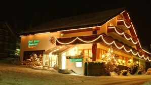 A hotel with a sign reading "Hotel Gonne Restaurant Melchiotte" at night, featuring a snow-covered landscape and illuminated exterior. - Hotel Sonne (Wildhaus-Alt St. Johann)