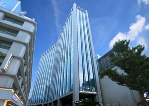 Un hotel moderno con fachada vertical, ventanas grandes y un letrero que dice "HOTEL GRACERY".