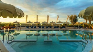 A pool area with umbrellas, lounge chairs, and a clear sky. - Hotel Panoramic (Caorle)