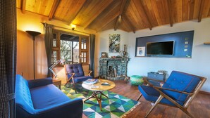 Una sala de estar acogedora con un sofá azul, una mesa de centro de madera y una chimenea de piedra.