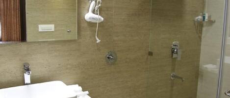 A bathroom with a shower, a sink, and a mirror.