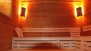 A sauna with wooden benches and wall-mounted lights.