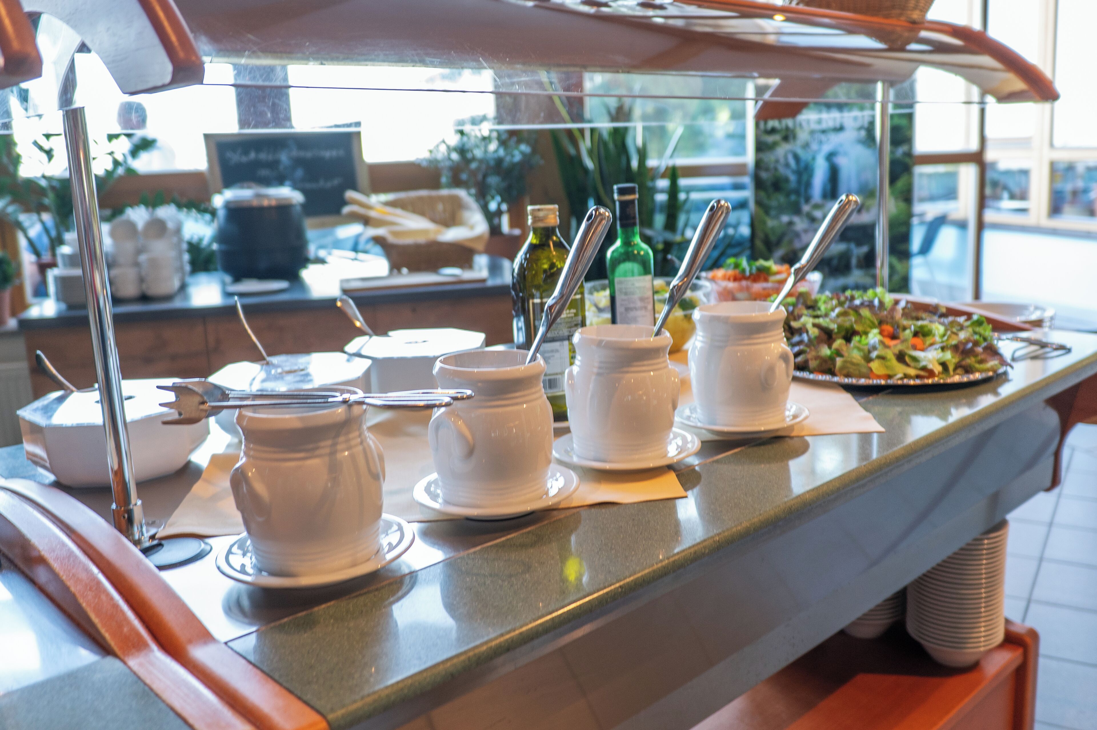 En buffetbod med forskellige retter og serveringsbestik.