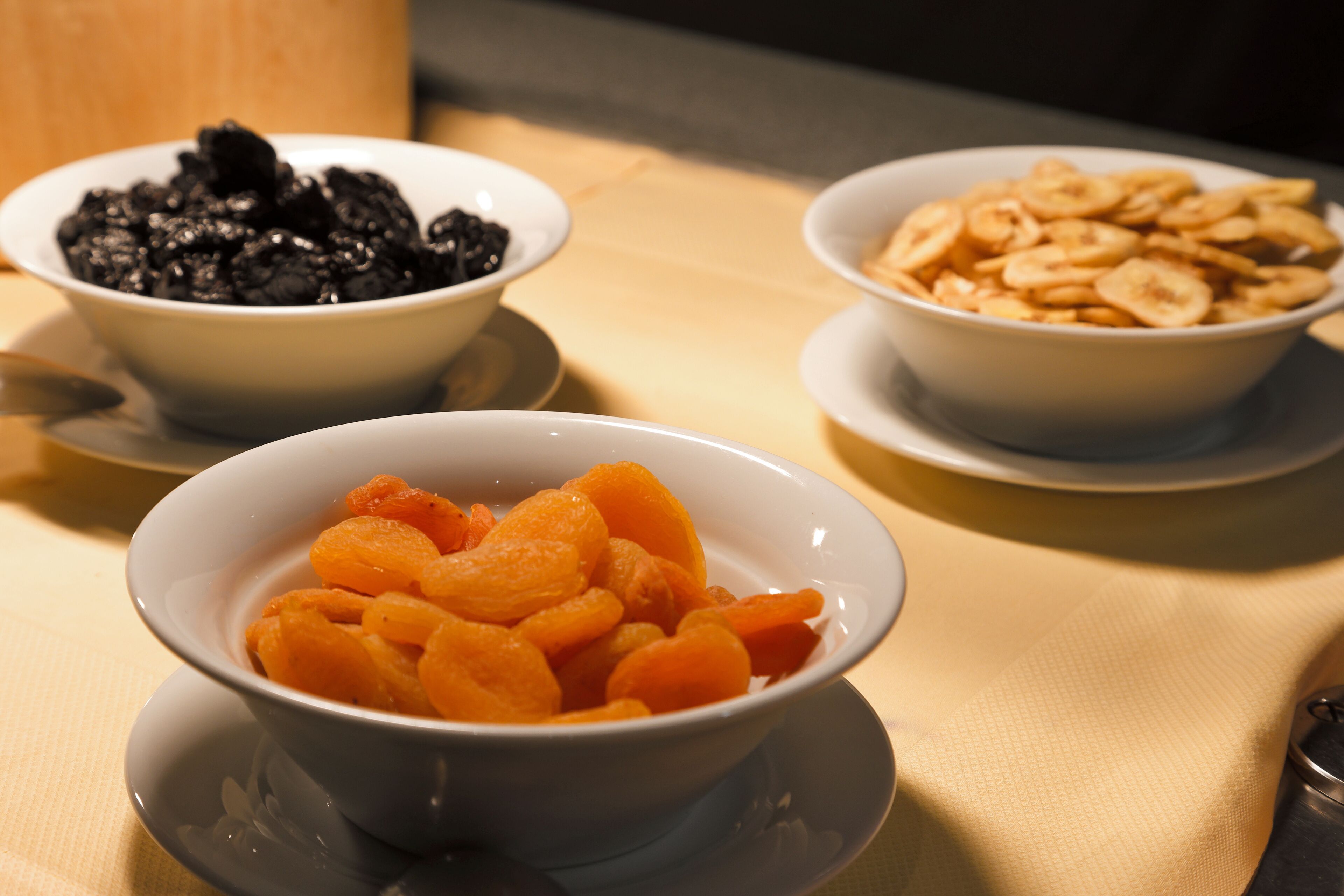 Three bowls of food on a table.