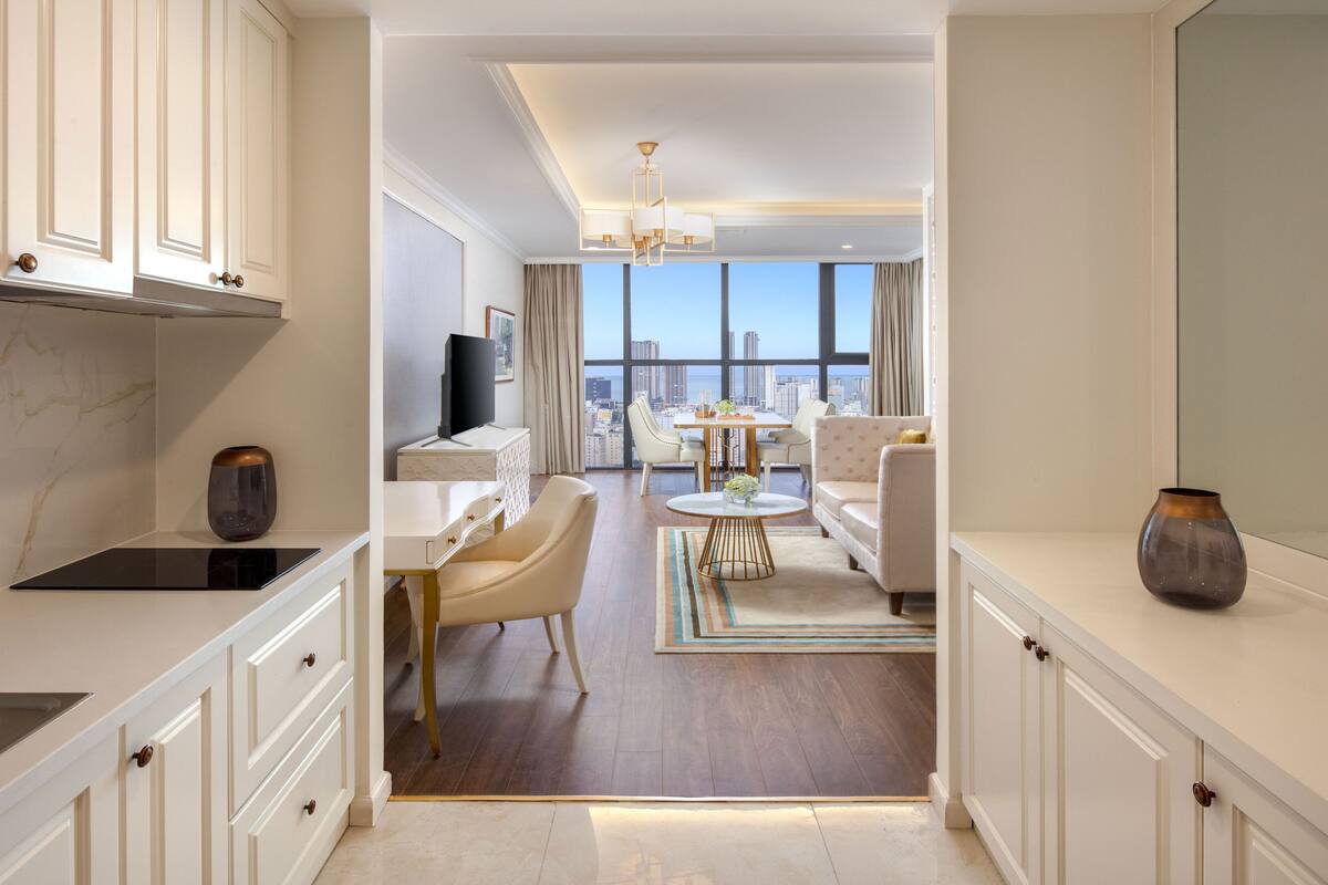 Ein modernes Hotelzimmer mit Küche, Essbereich und Sitzgelegenheit.