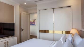 Una habitación de hotel con cama, televisor, armario y lámpara.