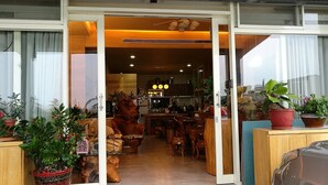 A modern interior with a wooden dining area, a kitchen, and a living space with potted plants. - Qi Hua Zhen Ju Homestay (Toucheng)