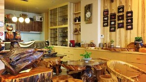 A kitchen with wooden furniture, a clock, and various kitchen items. - Qi Hua Zhen Ju Homestay (Toucheng)