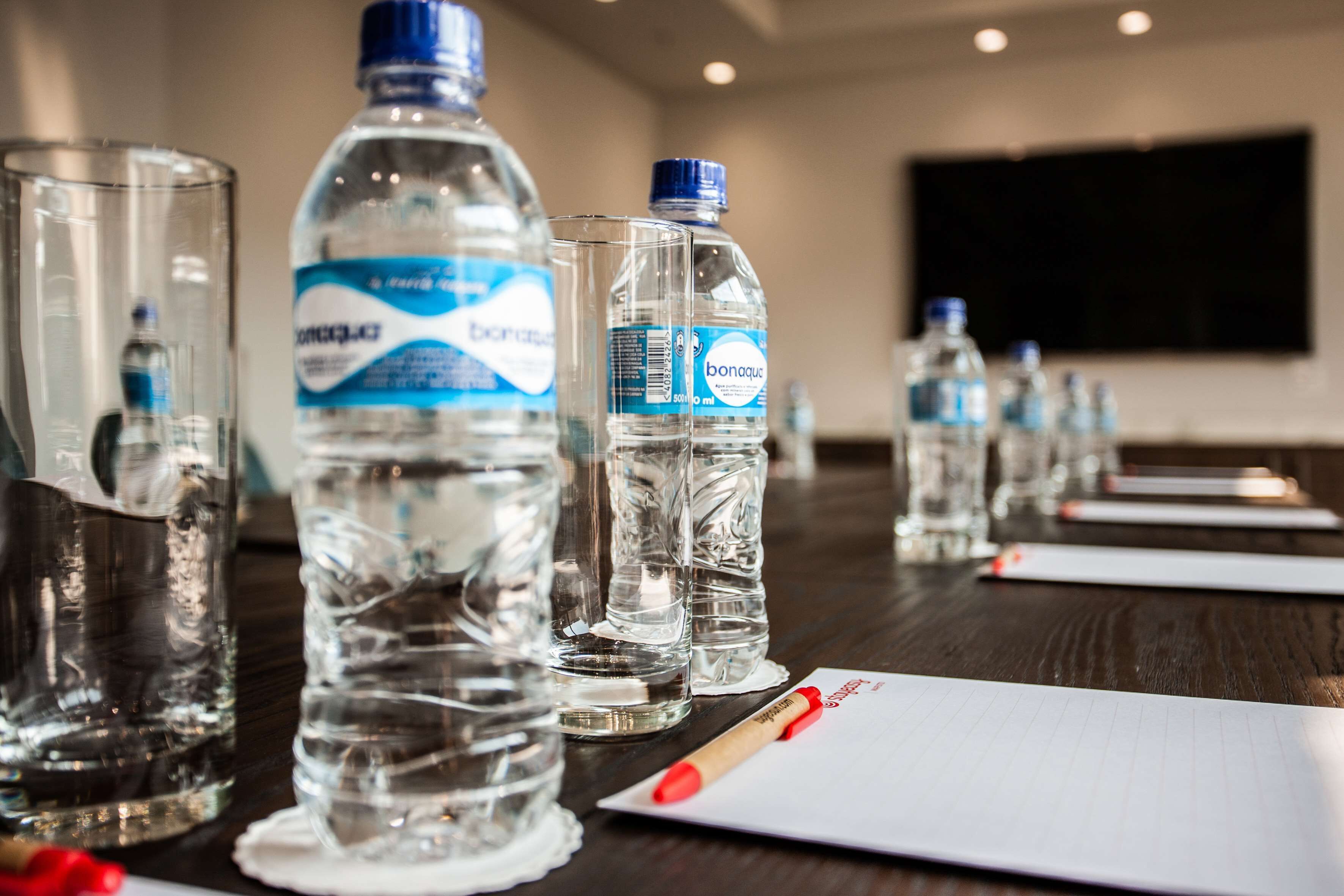 A conference table with water bottles and a notepad.