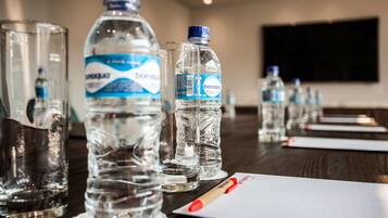 A conference table with water bottles and a notepad.