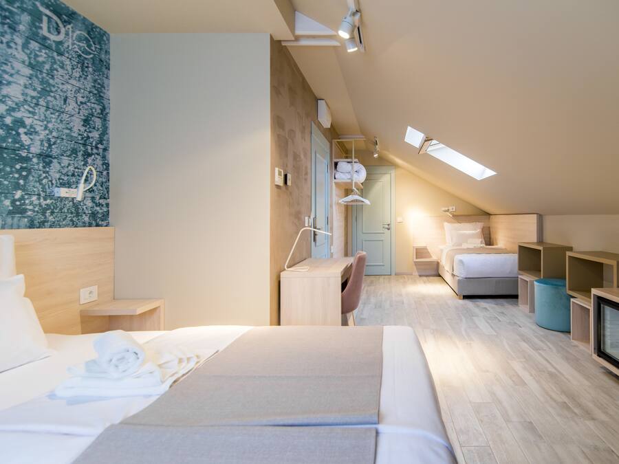 Una habitación de hotel moderna con una cama grande, un escritorio y una zona de estar.