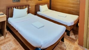 A room with two wooden beds, a ceiling light, and an air conditioning unit. - Lampang Bouteak Resort (Lampang)