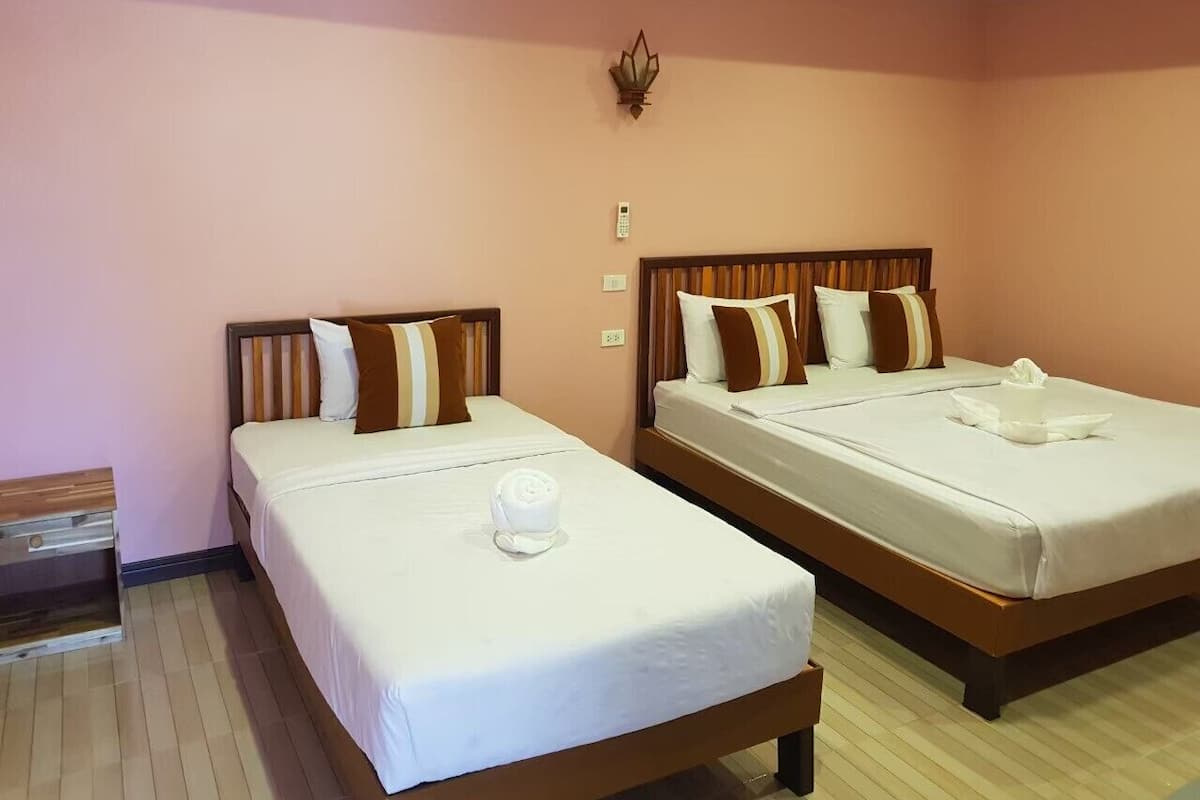 Two single beds with wooden headboards, white bedding, and brown pillows.