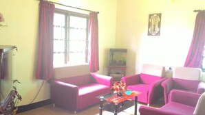 A living room with purple sofas, a glass coffee table, and a fish tank.