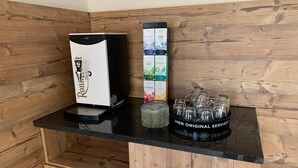 A kitchen with a coffee machine, a coffee pod holder, and a glass carafe on the counter. - Hotel Dachsbaude & Kammbaude (Neuhausen)