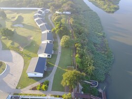 Vista aérea de una propiedad junto al lago, con varias casas, un sendero y un muelle.