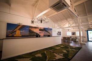Un hall espacioso con un gran mural, una araña y una alfombra estampada.