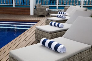 Una piscina al aire libre, tumbonas