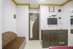 Relax in a stylish room with a sofa, flat-screen TV, and wooden cabinet.