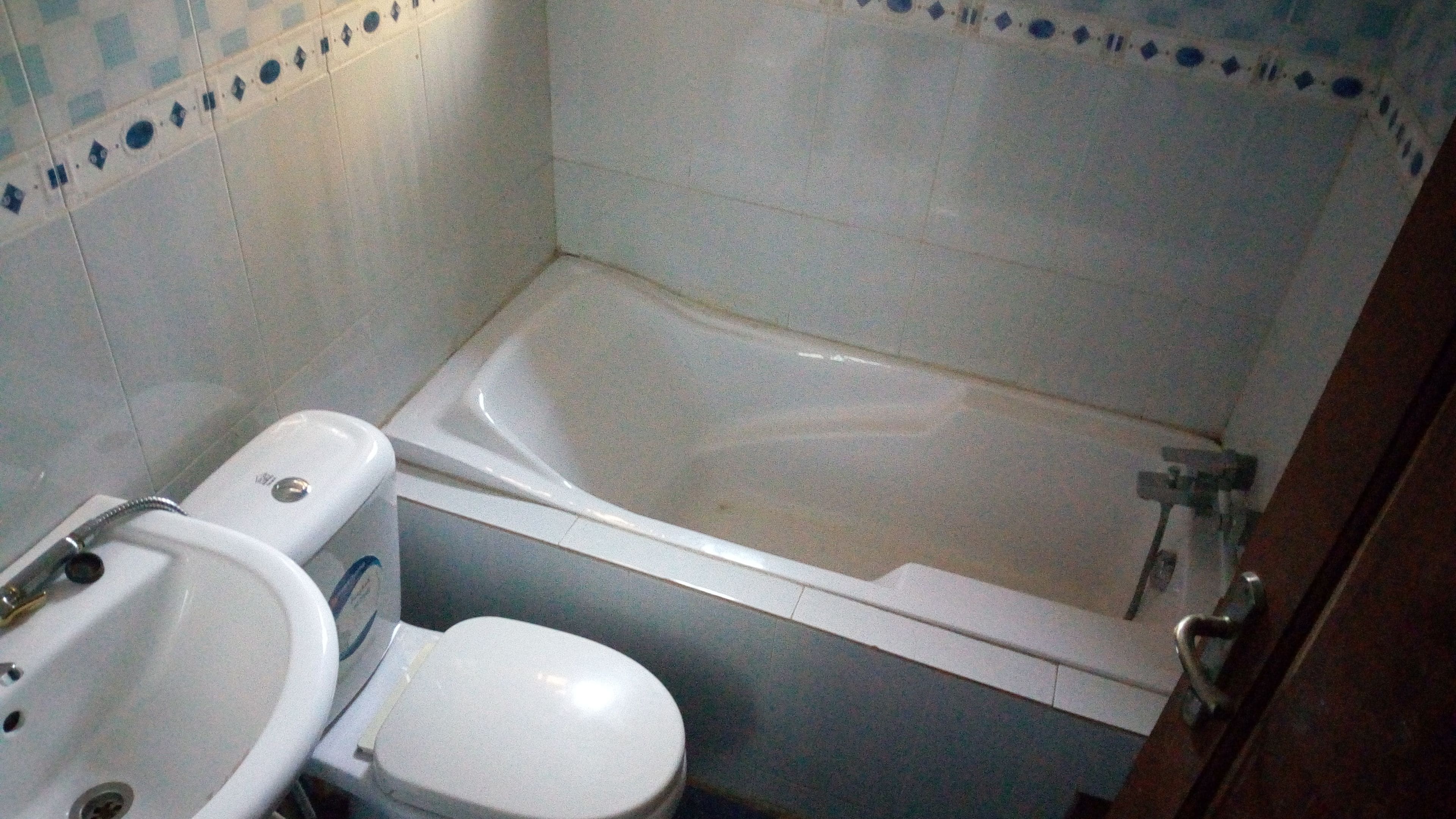 Une petite salle de bain avec une baignoire, des toilettes et un lavabo.