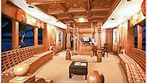 A spacious room with a high ceiling, wooden beams, and a central seating area with a table and chairs. - GuestHouser 3 BHK Houseboat e567 (Kuttanad Taluk)