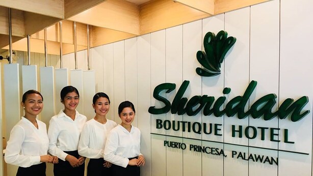 Naamplaatje voor het Sheridan Boutique Hotel met een logo en informatie over de locatie.