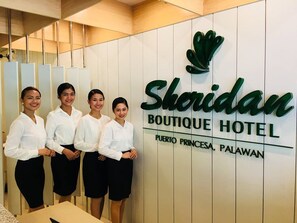 Une enseigne pour le Sheridan Boutique Hotel, avec un logo et les coordonnées de l’établissement.