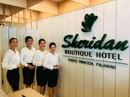 A sign for Sheridan Boutique Hotel with a logo and location details.