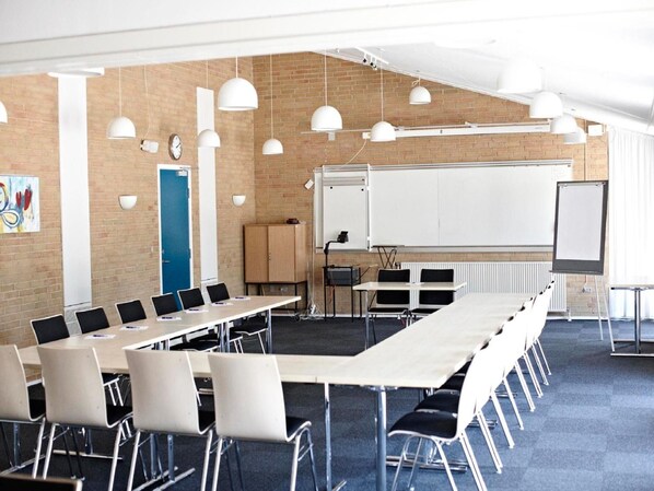 A conference room with a long table, chairs, a whiteboard, and pendant lighting. - Danhostel Fredericia (Fredericia)