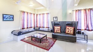 A modern living room with a sectional sofa, a coffee table, and a patterned rug. - GuestHouser 3 BHK Bungalow c477 (Mawal)