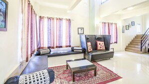 A spacious living room with a sofa set, a coffee table, and a patterned rug. - GuestHouser 3 BHK Bungalow c477 (Mawal)