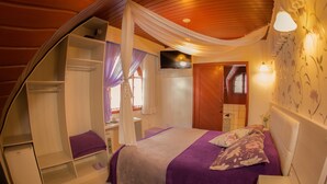 Een slaapkamer met een bed, een kledingkast, een kaptafel en een televisie.