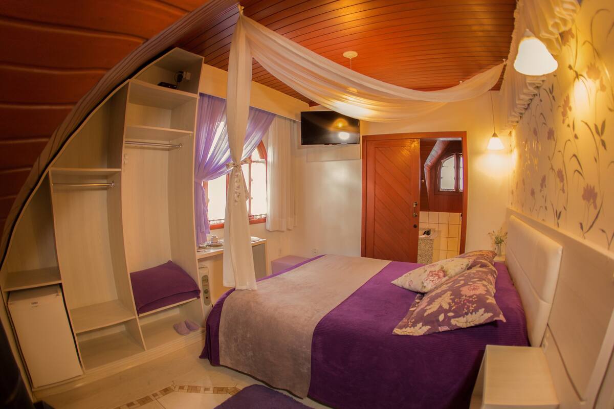 Une chambre à coucher comprenant un lit, une armoire, une coiffeuse et un téléviseur.