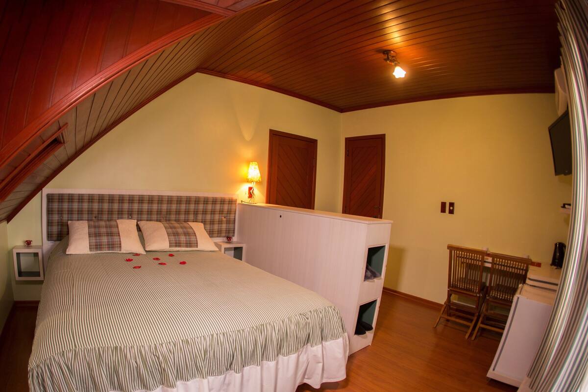 Une chambre à coucher comprenant un lit, des tables de chevet, un bureau et une chaise.