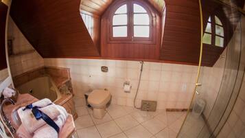 Un baño con bañera, inodoro y ducha.