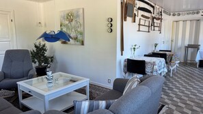 Een woonkamer met een bank, fauteuil, salontafel en een schilderij.