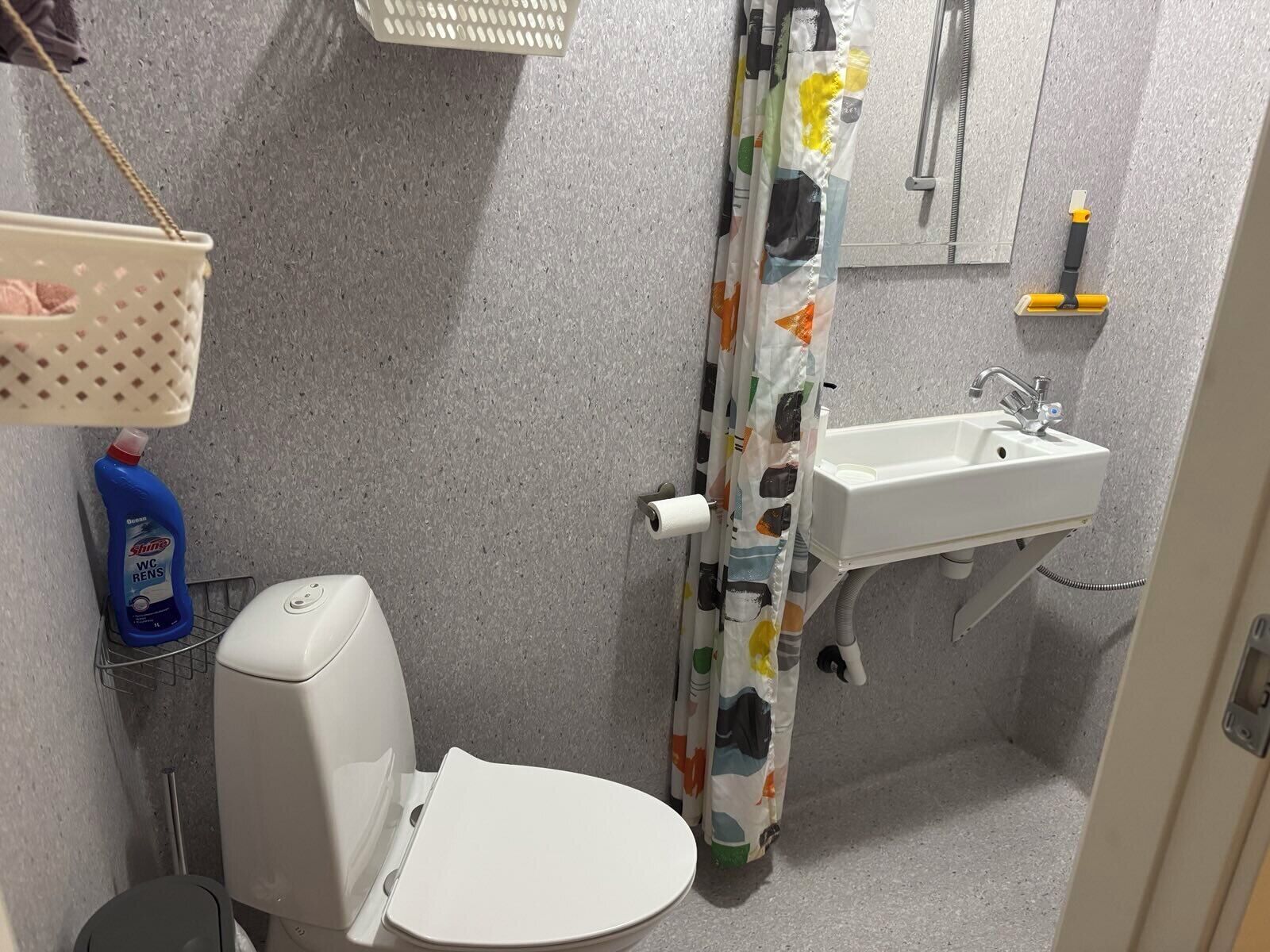 Un bagno piccolo con il water, un lavandino e una tenda da doccia.