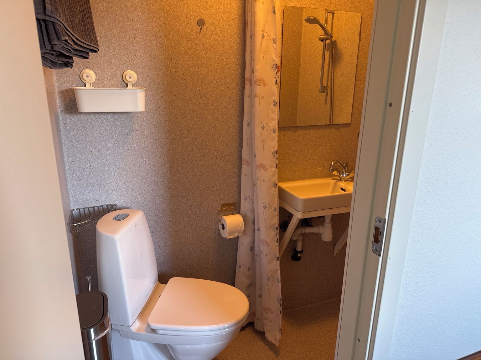 Ein kleines Badezimmer mit Toilette, Dusche und Waschbecken.