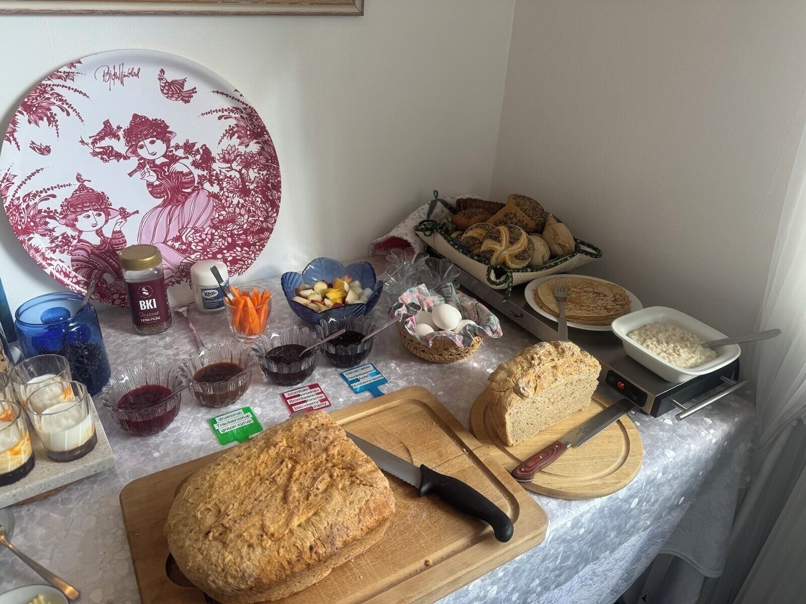 A breakfast buffet with various food items, including bread, fruits, and condiments.