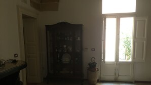 Ein Zimmer mit Schachbrettmuster-Teppich, einem Holzkästen mit Geschirr und einer Tür mit Fenster.
