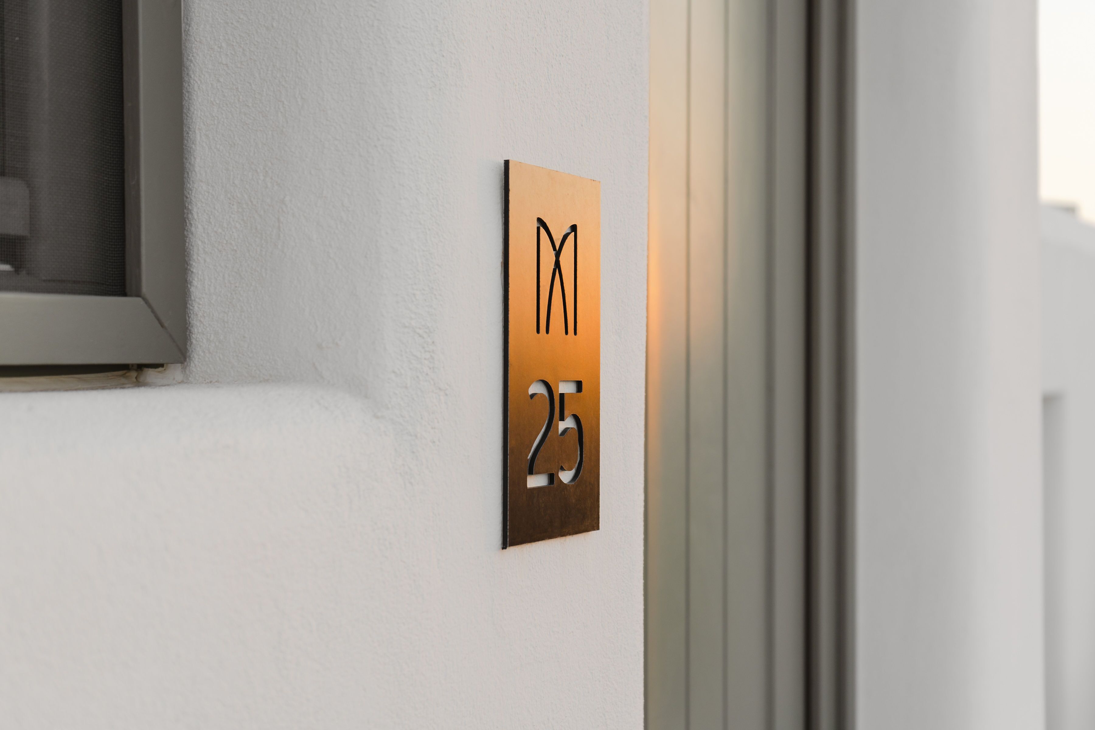 A wall-mounted sign with a large number '25' and a stylized 'M' above it.