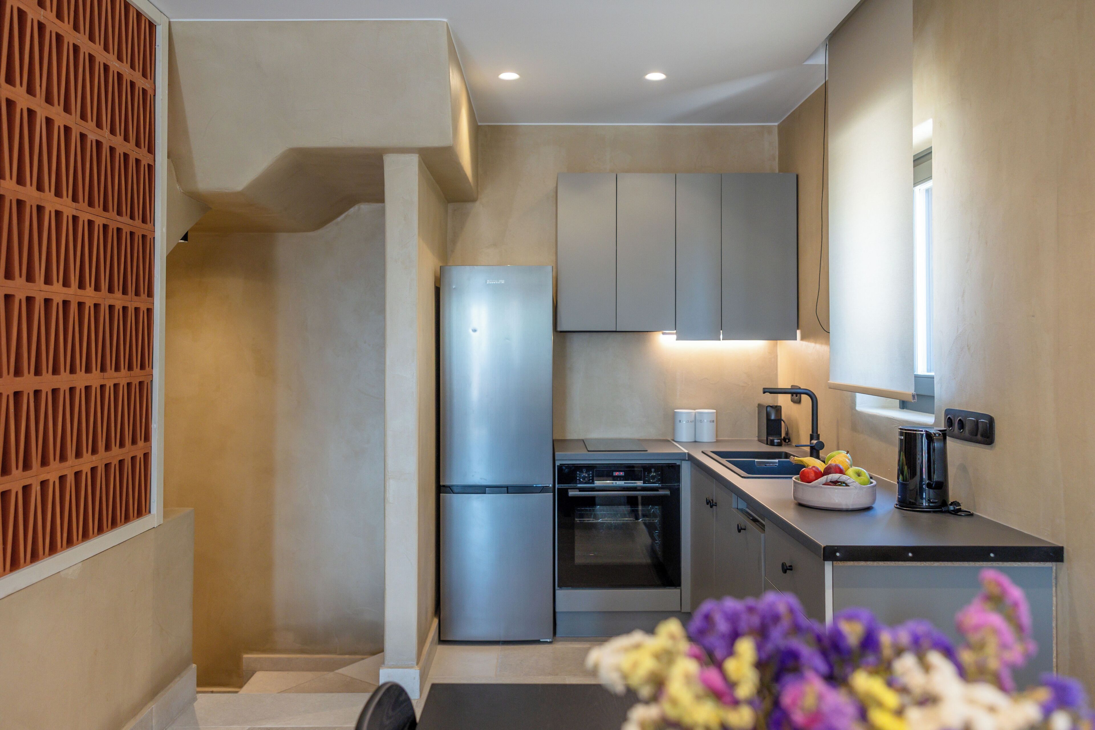 A modern kitchen with stainless steel appliances, a built-in oven, and a sink.