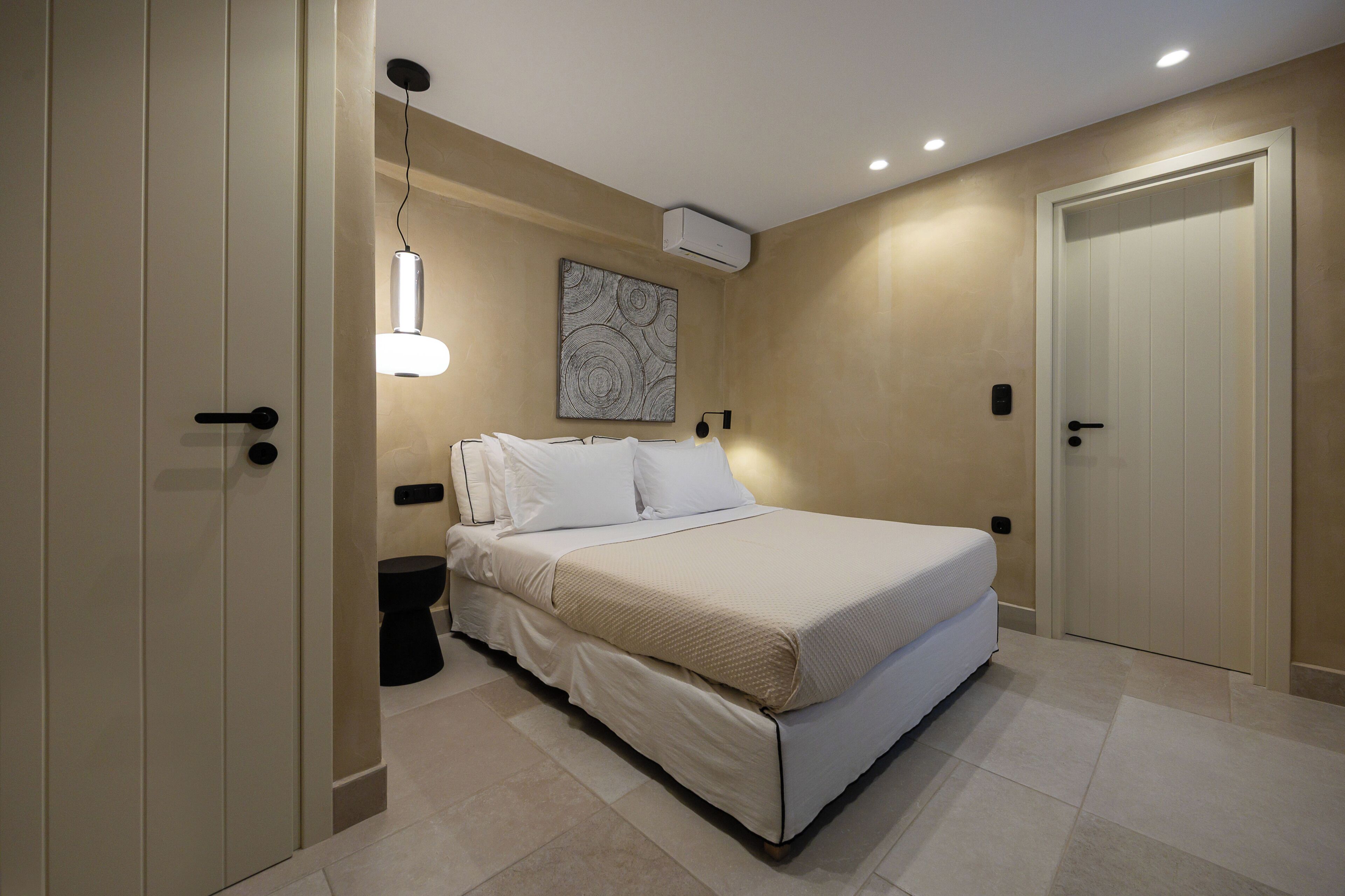 A bedroom with a bed, bedside tables, a wall-mounted artwork, and a door.