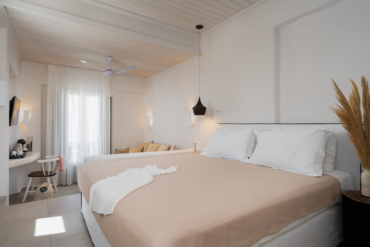 A bedroom with a large bed, a desk, and a chair.