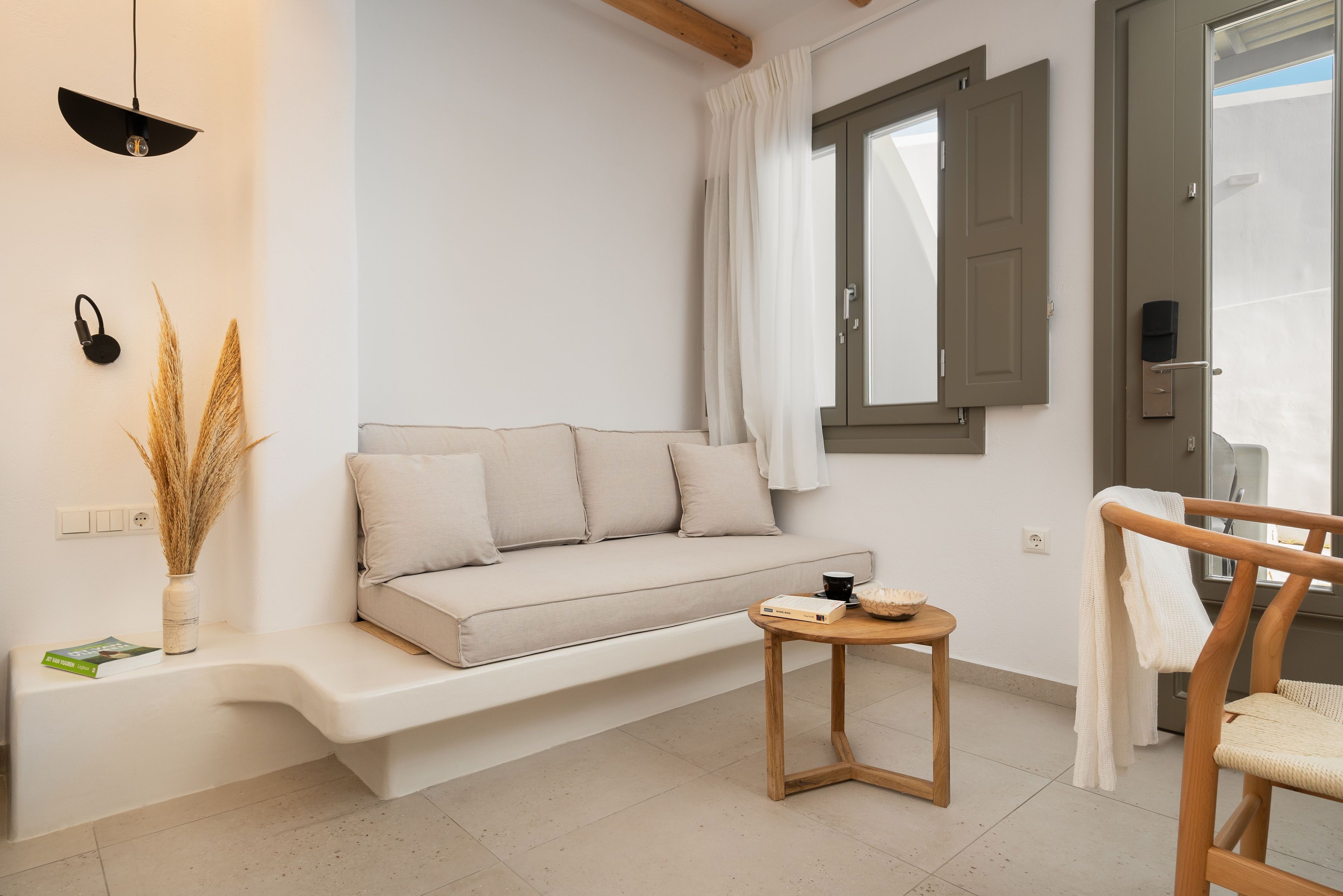 A modern living room with a sofa, a small wooden table, and a chair.