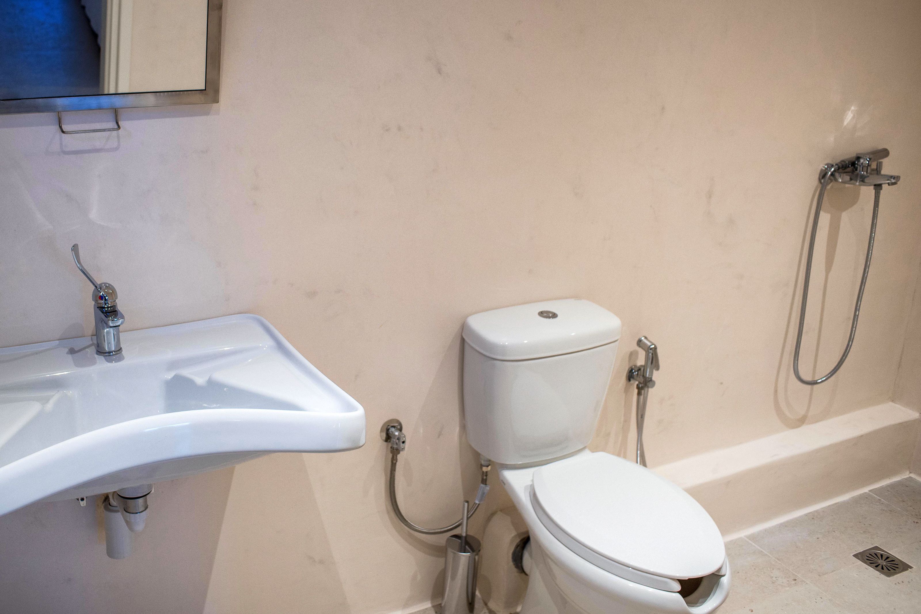 A bathroom with a white sink, toilet, and shower.