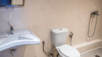 A bathroom with a white sink, toilet, and shower.
