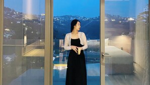 A woman standing on a balcony with a city view, holding a banana. - The Luxe Hotel Da Lat (Xuan Huong - Da Lat)